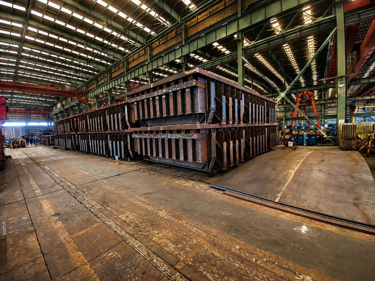 Row of cathode shells under fabrication in a large steel workshop hall