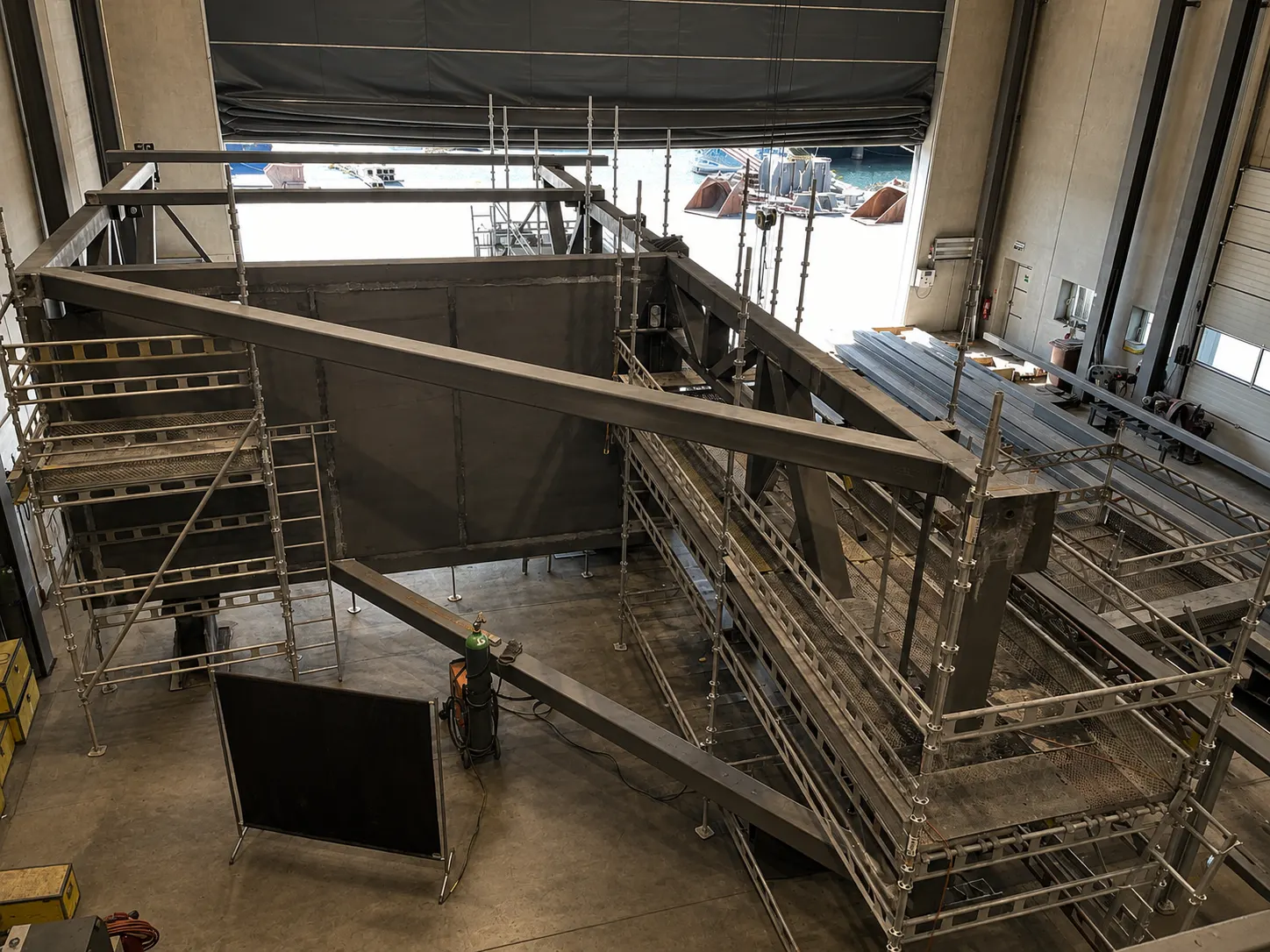 Large fabricated steel structure with scaffolding inside a quayside hall