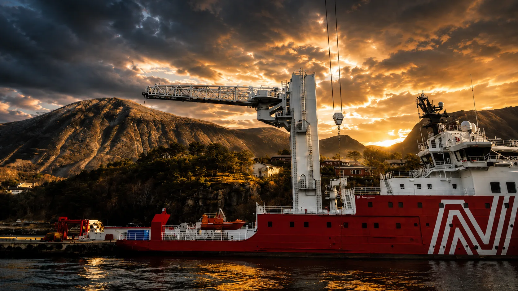Offshore support vessel with crane at sunset